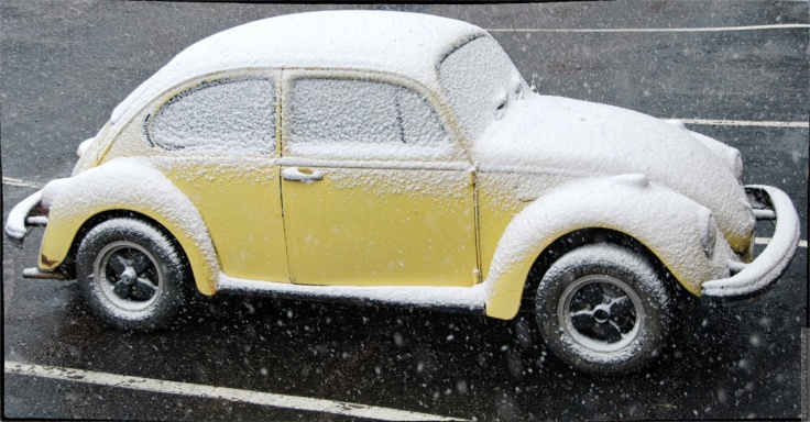 Yellow VW Beetle covered in snow